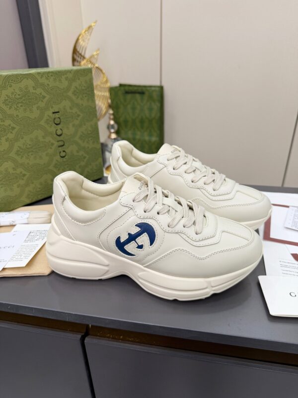 sy_no_61C110CC52F69EBD6044D3BF0BF10672_1 Gucci Rhyton Leather Sneaker in Off-White with Blue Interlocking G Logo