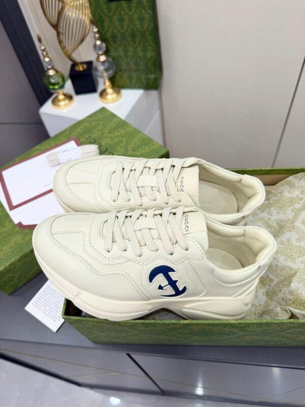 sy_no_61C110CC52F69EBD6044D3BF0BF10672_4 Gucci Rhyton Leather Sneaker in Off-White with Blue Interlocking G Logo