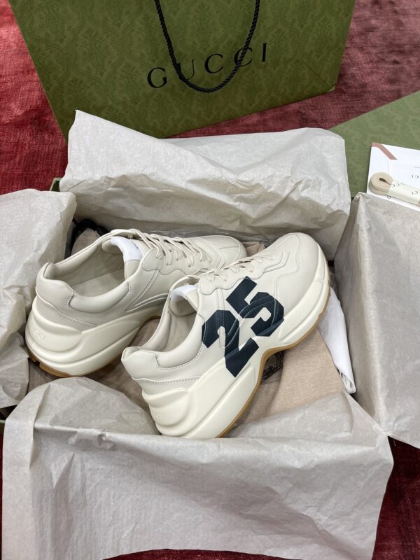 sy_no_627D806077E74C3578EE15D5D1F7D27D_0 Gucci Rhyton Ivory Leather “25” Print Chunky Sneakers