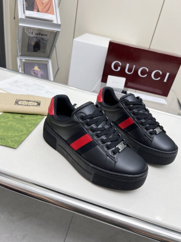 sy_no_E8AE8785DE69A5CB5CDE27786E519D94_1 Gucci Black Leather Chunky Sneaker with Red/Blue Web Stripe & Red Heel Detail