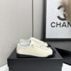 sy_no_EBE9D714E87BFE3714AEF0457AC9E1B2_0 Chanel Off-White and Black Patent Cap-Toe Low-Top Sneaker with CC Lace Lock